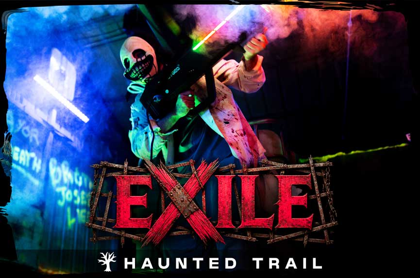 A terrifying figure wearing a grinning, stitched-mouth mask aims a futuristic laser weapon through thick fog illuminated by neon blue and red lights. The text reads "Exile Haunted Trail."